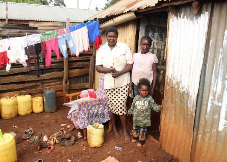 Veronica with two of her children at their old home before the housing project