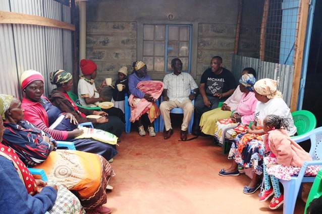 Beneficiaries meet together in a community space.