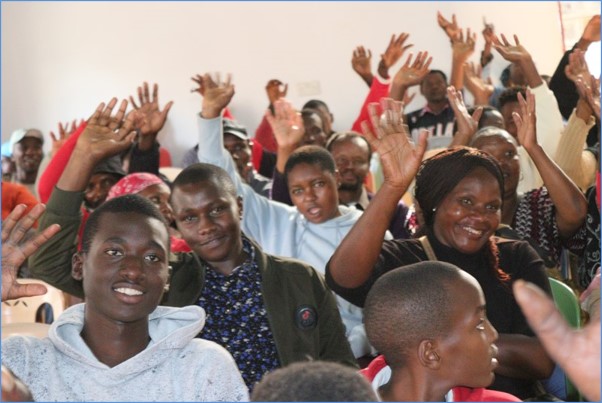 Hands raised as young people join in.