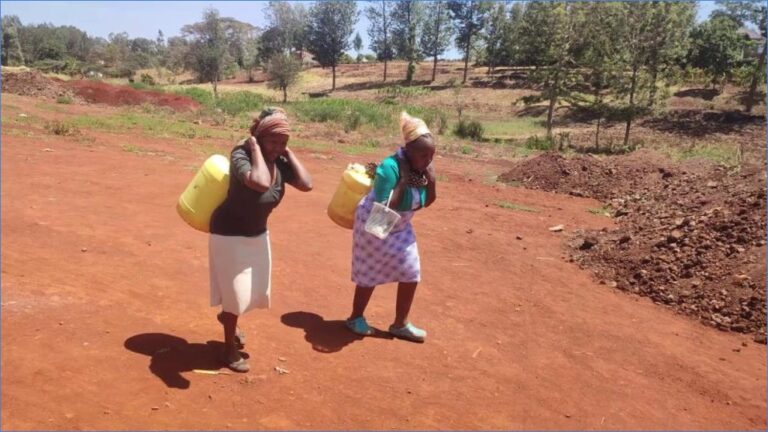 Children carry clean water home along the red-earth paths of Kanjeru.